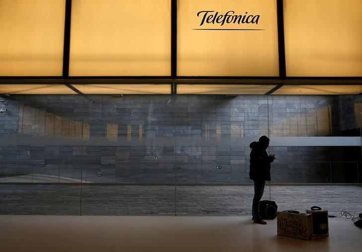 © Reuters. A man stands under a logo of Spain's telecom giant Telefonica at the company's headquarters in Madrid