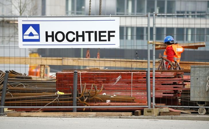 © Reuters. A worker of German construction company Hochtief walks passed the company's logo in Essen