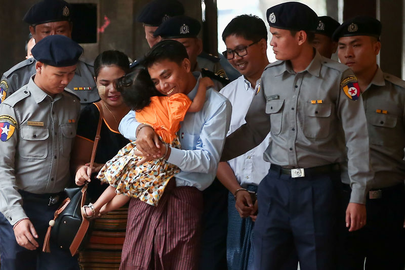 © Reuters. Detained Reuters journalist Kyaw Soe Oo hugs his daughter as he is escorted by police, arrives for a court hearing in Yangon