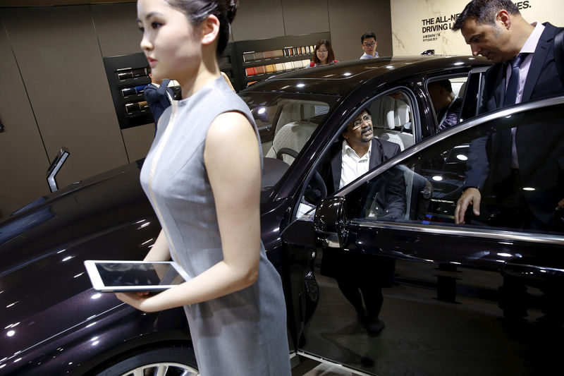 © Reuters. FILE PHOTO: People check out the new BMW M760Li xDrive as it is presented during the Auto China 2016 auto show in Beijing