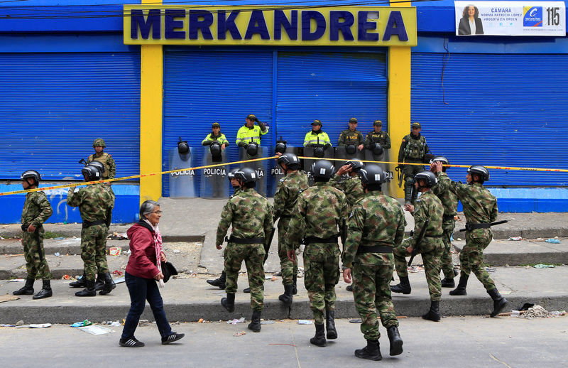 © Reuters. Colombian police and soldiers guard a supermarket supposedly linked to FARC in Bogota