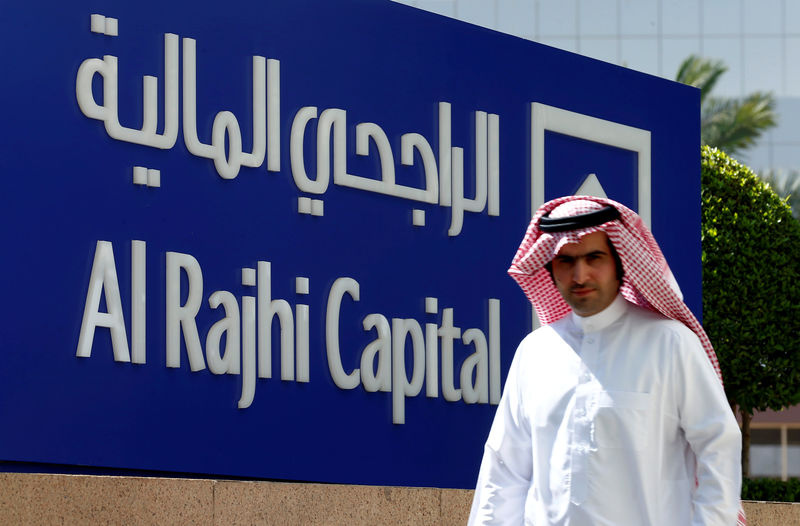 © Reuters. FILE PHOTO:A man walks past a sign of Al Rajhi Capital company in Riyadh