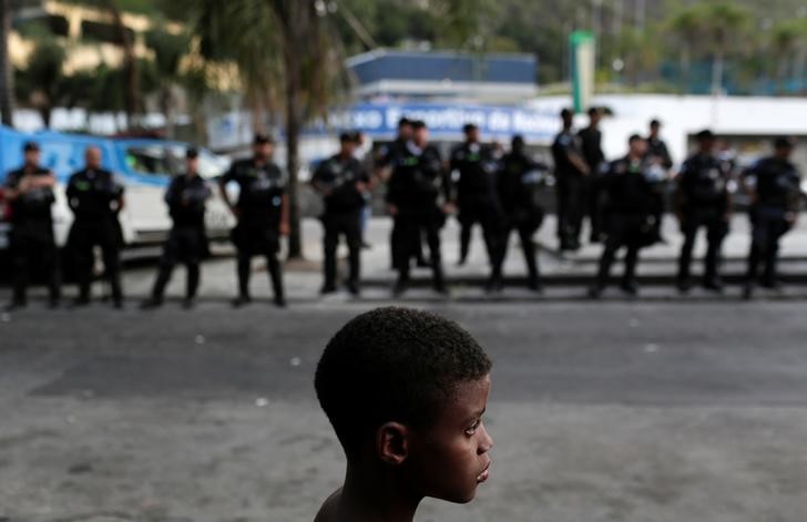 © Reuters. Menino participa de protesto contra violência na favela da Rocinha no Rio de Janeiro