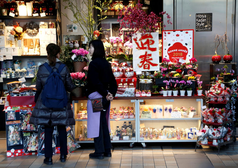 © Reuters. FILE PHOTO: A clerk talks to a customer at a flower shop at a shopping mall in Tokyo