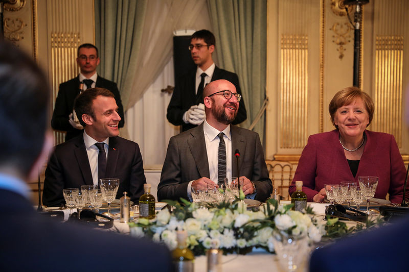 © Reuters. Belgian PM Michel sits between French President Macron and Germany's Chancellor Merkel during a dinner with EU leaders at Val Duchesse castle in Brussels