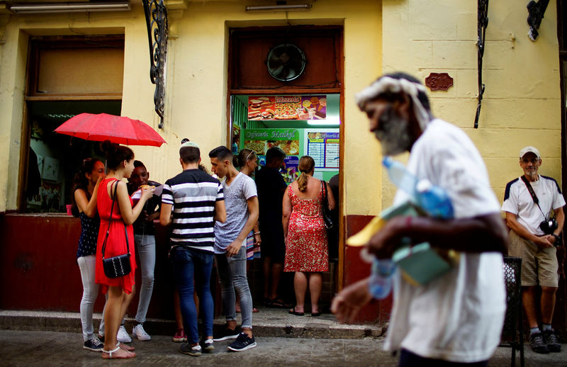 © Reuters. FILE PHOTO: People stand in front of a private restaurant in Havana, Cuba