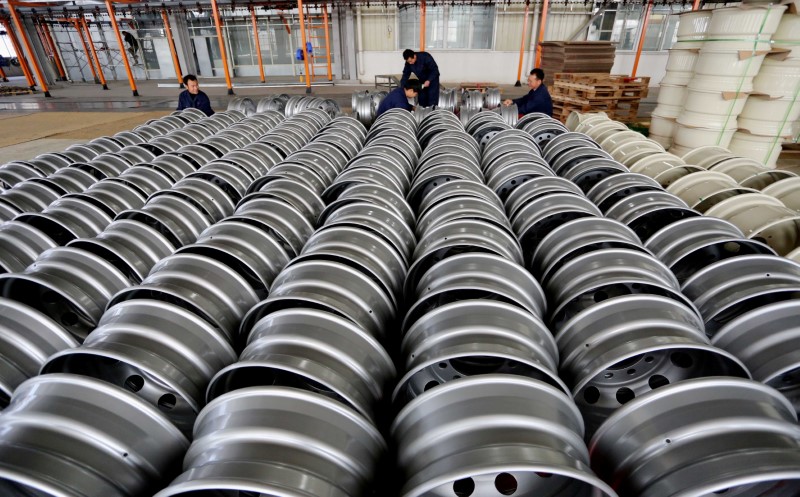 © Reuters. Workers arrange steel rims for export at a wheel factory in Lianyungang