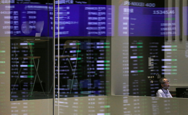 © Reuters. Market prices are reflected in a glass window at the TSE in Tokyo