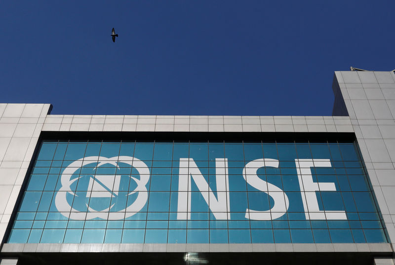 © Reuters. A bird flies past the logo of National Stock Exchange (NSE) installed on the facade of its building in Mumbai