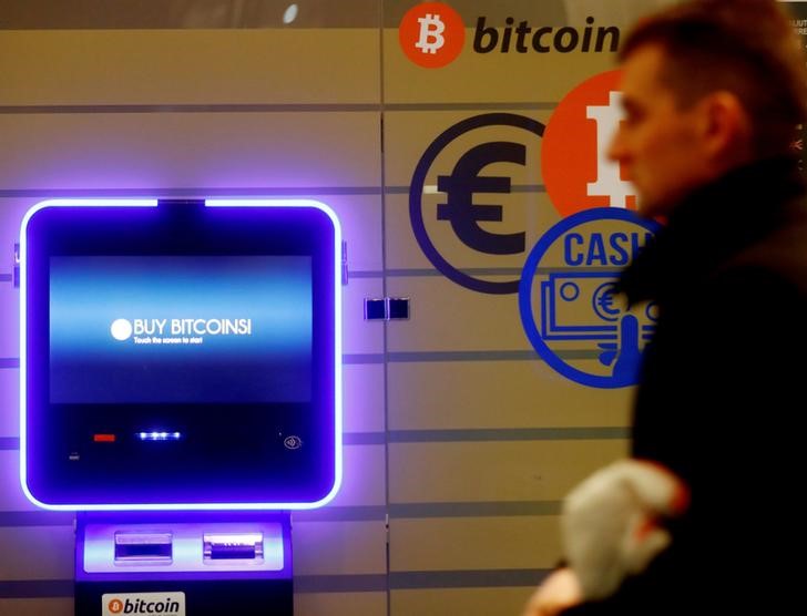 © Reuters. A man walks past a bitcoin ATM in Vilnius