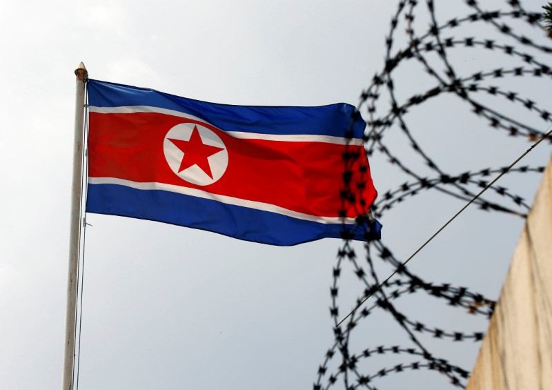 © Reuters. La bandera de Corea del Norte ondea cerca de un muro con alambre de espinos la embajada norcoreana en Kuala Lumpur, Malasia.