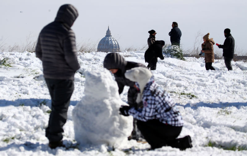 © Reuters. Pessoas brincam com neve perto da Basílica de São Pedro em Roma