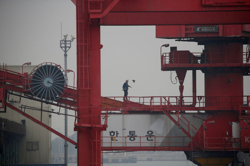 © Reuters. FILE PHOTO: An employee walks on a crane at a container terminal at Incheon port in Incheon