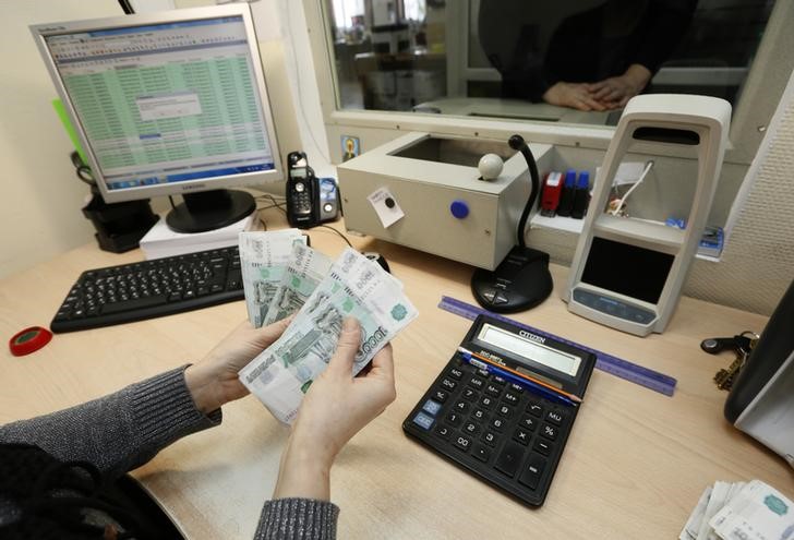 © Reuters. Кассир частной компании считает банкноты перед тем, как выдать зарплату