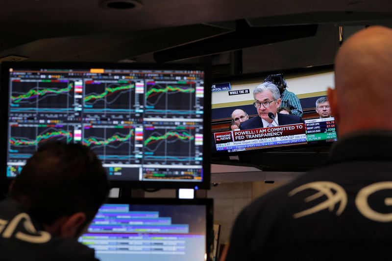 © Reuters. Federal Reserve Chairman Jerome Powell speaks on a television as traders work on the floor of the New York Stock Exchange in New York