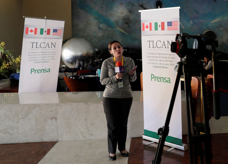 © Reuters. A journalist speaks next to NAFTA banners inside a hotel where the seventh round of NAFTA talks involving the United States, Mexico and Canada takes place in Mexico City