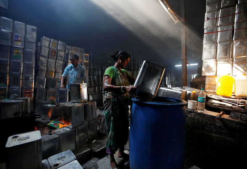 © Reuters. A woman cleans used cooking oil tins in a recycling workshop in Mumbai
