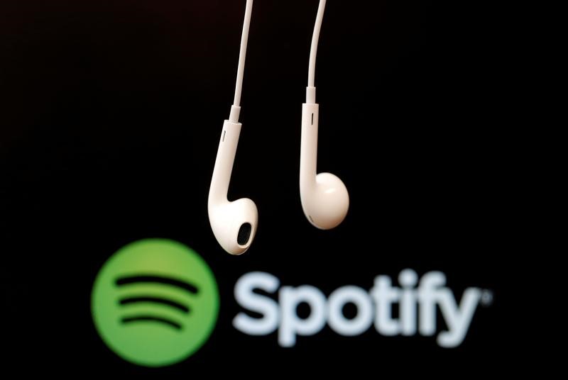 © Reuters. Fones de ouvido vistos em frente a logo de empresa de serviços de streaming Spotify