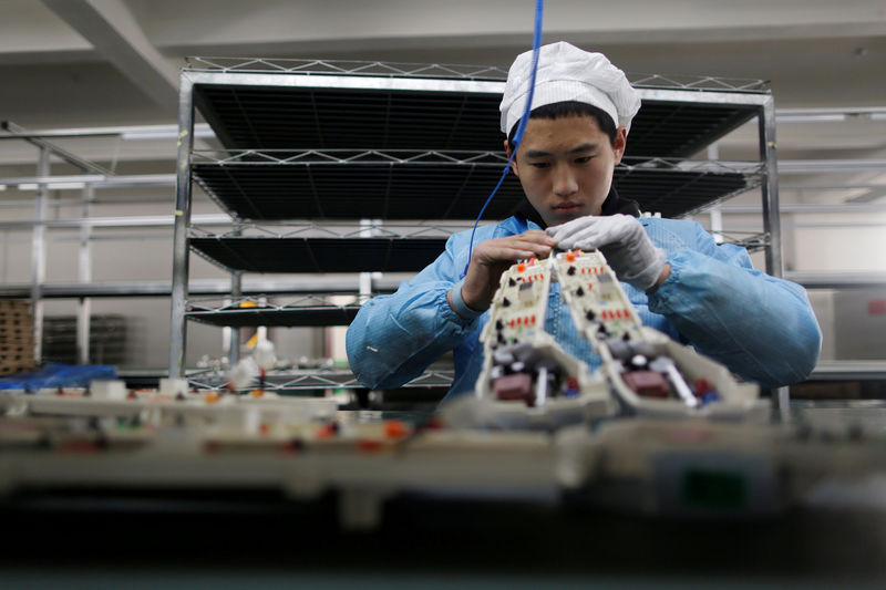 © Reuters. FILE PHOTO: Labourer works inside an electronics factory in Qingdao