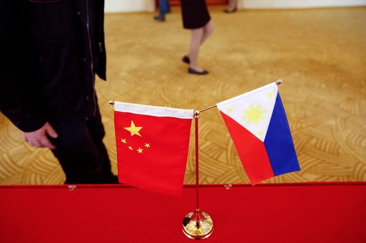 © Reuters. National flags are placed outside a room where Philippine Finance Secretary Carlos Dominguez and China's Commerce Minister Gao Hucheng address reporters after their meeting in Beijing