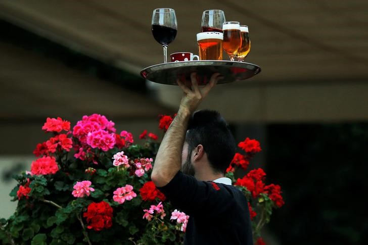 © Reuters. A waiter carries a tray with drinks at the terrace of a restaurant in downtown Malaga