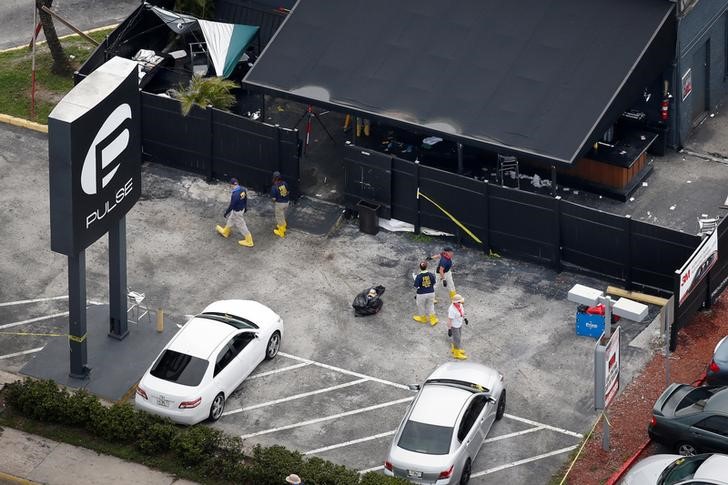 © Reuters. FBI officials collect evidence from Pulse gay night club parking lot some days after mass shooting in Orlando