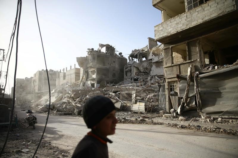 © Reuters. Menino caminha perto de locais destruídos em Ghouta