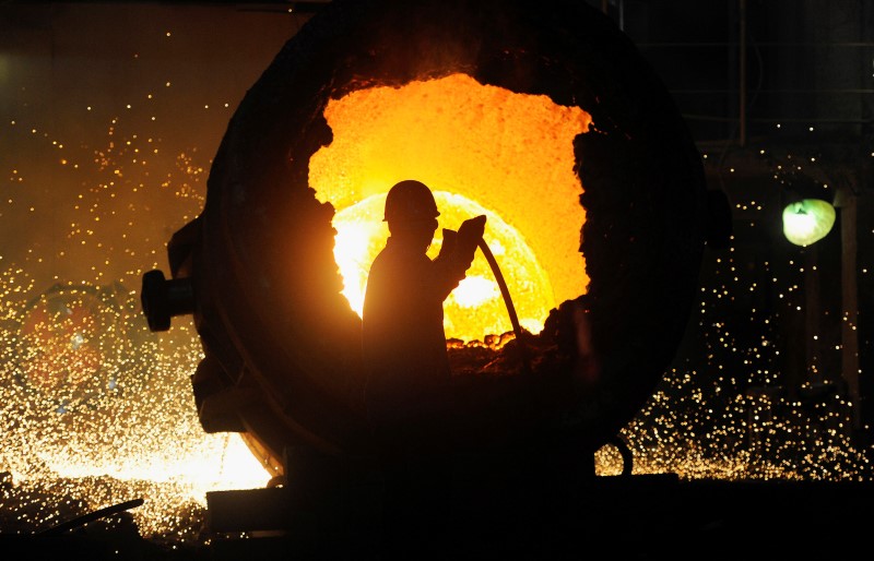 © Reuters. FILE PHOTO: A worker operates a furnace at a steel plant in Hefei