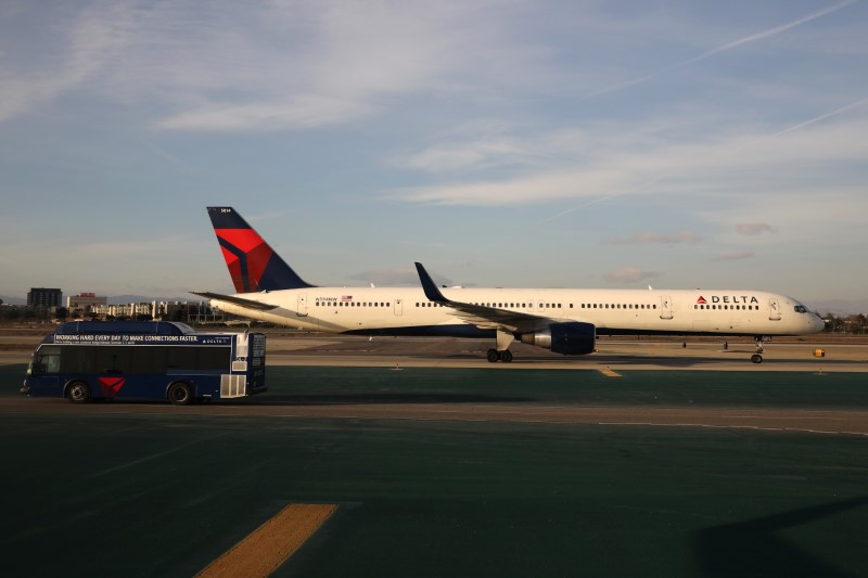 © Reuters. A Delta plane passes a Delta bus on the tarmac at LAX airport in Los Angeles