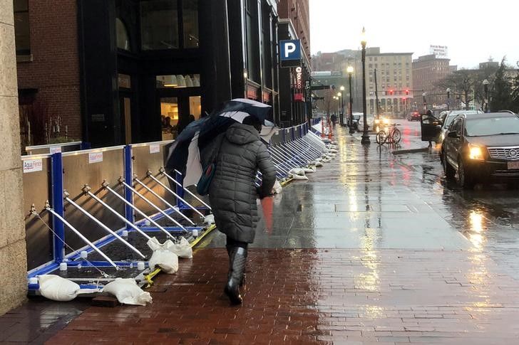 © Reuters. Transeunte passa em frente a prédio protegido por barreiras contra enchentes em Boston