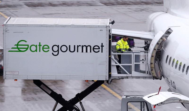 © Reuters. Gate Gourmet staff, part of Swiss airline catering firm Gategroup Holdings, loads a trolley aboard an Airbus A320-214 airplane of Swiss airline at Zurich airport