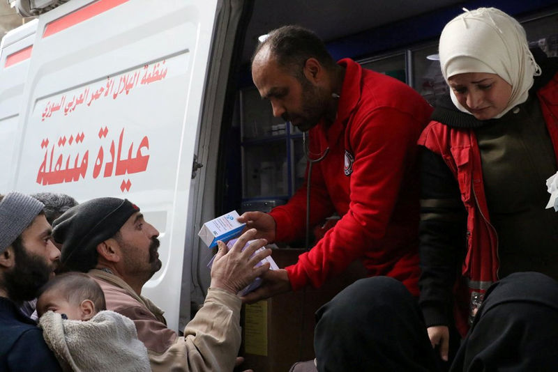 © Reuters. Voluntários da organização humanitária Crescente Vermelho entregam suprimentos médicos a civis em Ghouta, na Síria