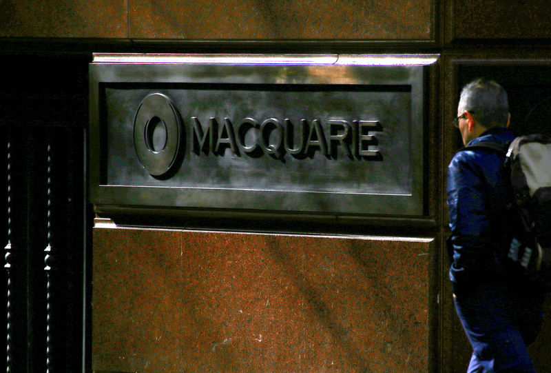 © Reuters. FILE PHOTO:A pedestrian walks past the logo of Australia's biggest investment bank Macquarie Group Ltd which adorns a wall on the outside of their Sydney office headquarters in central Sydney, Australia