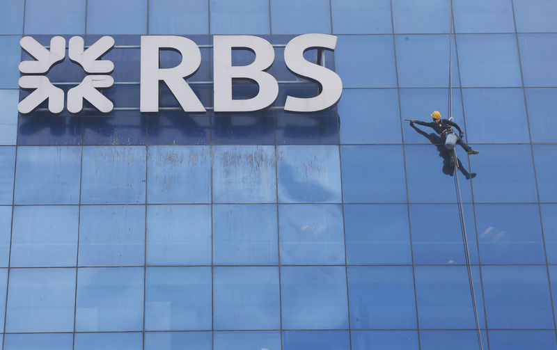 © Reuters. FILE PHOTO: Worker cleans the glass exterior next to the logo of RBS (Royal Bank of Scotland) bank at a building in Gurugram