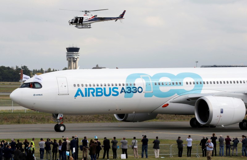 © Reuters. People celebrate near an Airbus A330neo aircraft after its maiden flight event in Colomiers near Toulouse, France