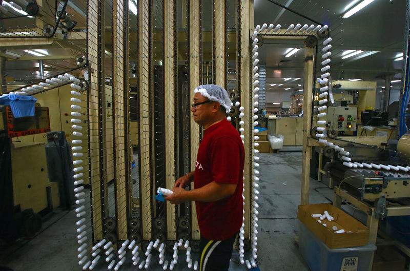 © Reuters. FILE PHOTO: Worker Noa Utumaru checks the production line at the factory of the Australian company Impact International, which designs and manufactures food, cosmetic and pharmaceutical tubes for domestic and international clients, located in western Sydne