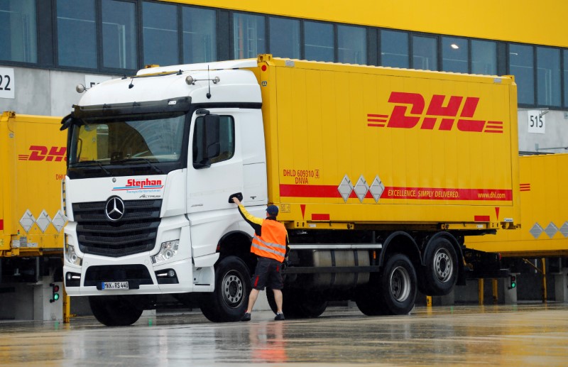 © Reuters. A worker opens a truck at a distribution centre of German postal and logistics group Deutsche Post DHL in Obertshausen
