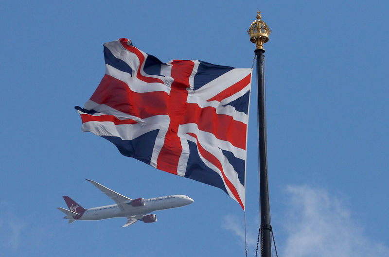 © Reuters. FILE PHOTO: A Virgin Atlantic passenger jet flies past the Union Flag above the Houses of Parliament in Westminster, in central London