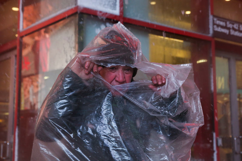 © Reuters. Homem se protege de neve em Manhattan, Nova York