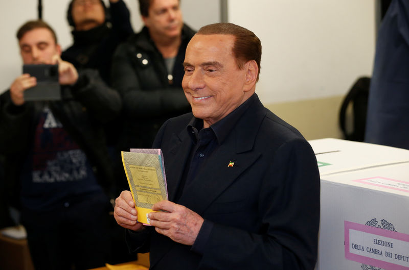 © Reuters. Il leader di Forza Italia, Silvio Berlusconi, al seggio elettorale