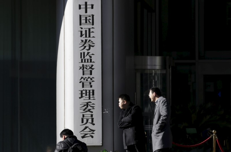 © Reuters. Men rest outside the headquarters building of China Securities Regulatory Commission in Beijing