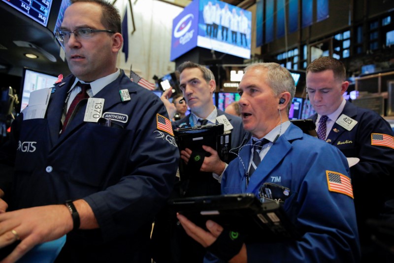 © Reuters. FILE PHOTO - Traders work on the floor at the New York Stock Exchange (NYSE) in Manhattan, New York