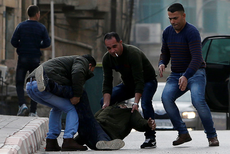 © Reuters. Homens retiram corpo de palestino morto a tiros durante confrontos com tropas israelenses na Cisjordânia