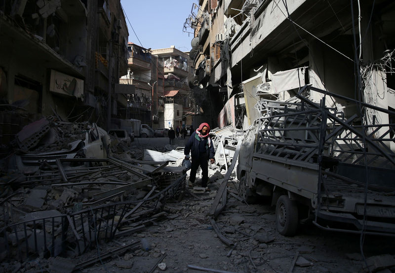 © Reuters. Homem passa por destroços de prédios na cidade de Douma, em Ghouta Oriental, na Síria