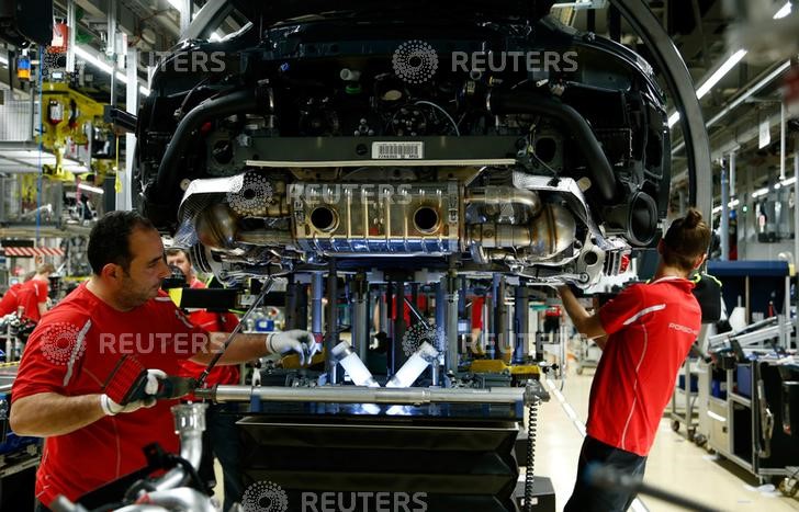 © Reuters. Employees of German car manufacturer Porsche work on a Porsche 911 Carrera 4S at the Porsche factory in Stuttgart-Zuffenhausen