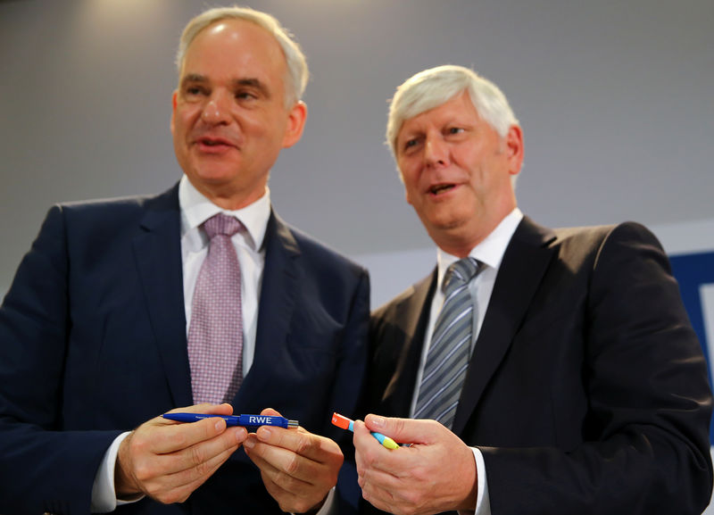 © Reuters. RWE and E.On CEOs Schmitz and Teyssen exchange pens following a news conference in Essen