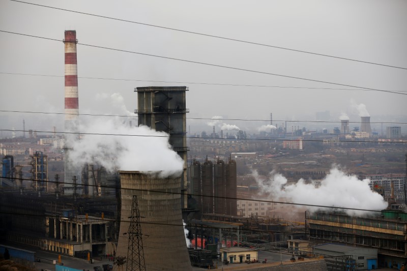 © Reuters. Cooling towers emit steam and chimneys billow in an industrial zone in Wu'an