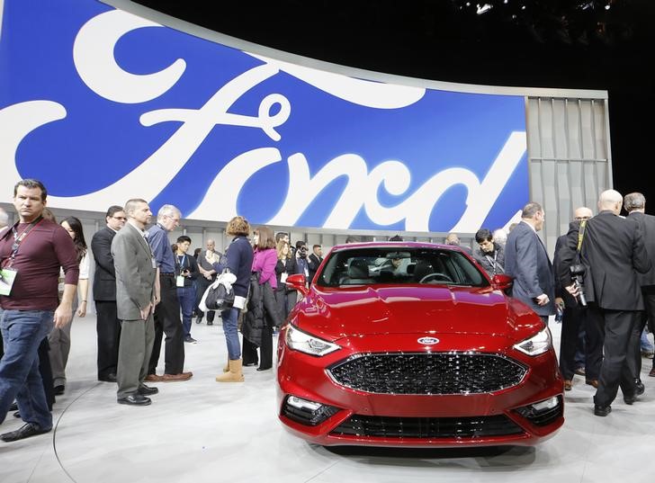 © Reuters. People crowd around a 2017 Ford Fusion being displayed at the North American International Auto Show in Detroit