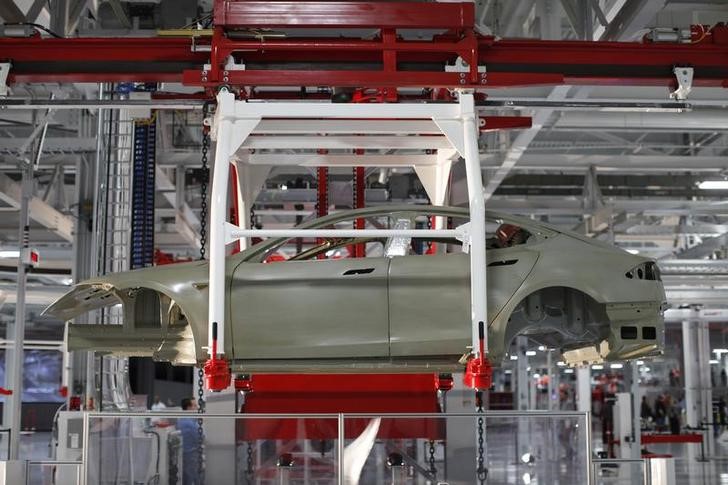 © Reuters. The body of a Tesla Model S is transported by an automated crane at the Tesla factory in Fremont