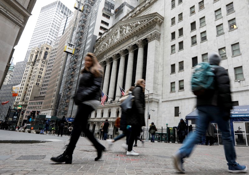 © Reuters. People walk on Wall St. in front of the NYSE in New York